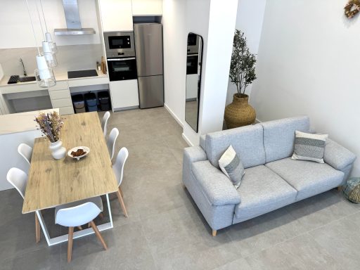 Salón y comedor modernos con muebles minimalistas y tonos neutros.